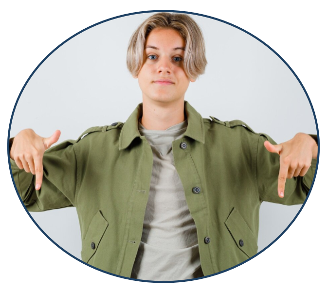 Chłopak w zielonej koszuli wskazuje na dol